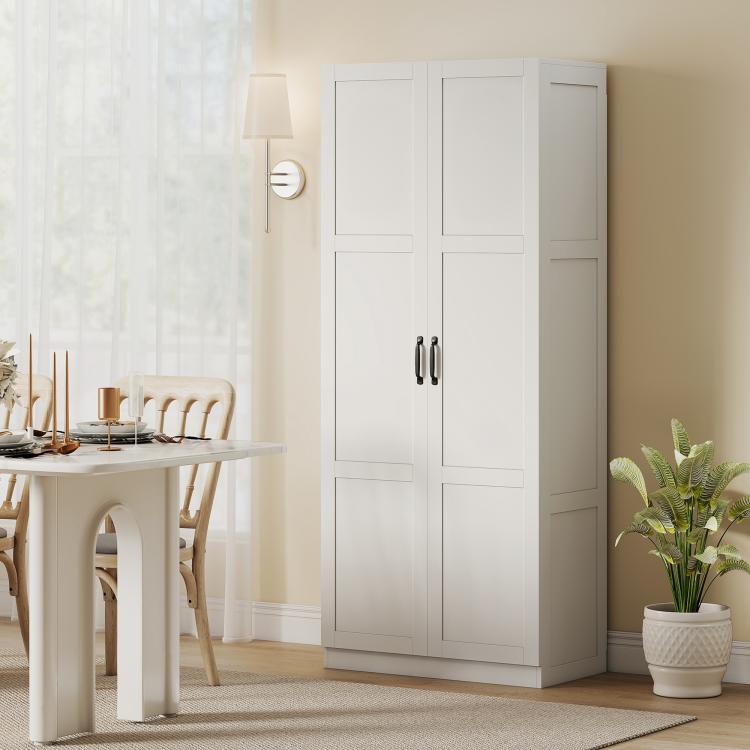 White tall pantry cabinet with paneled doors and black handles in a home setting