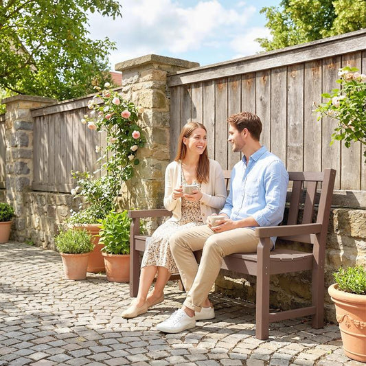 Brown 2-person outdoor garden bench with slatted back and seat on a patio