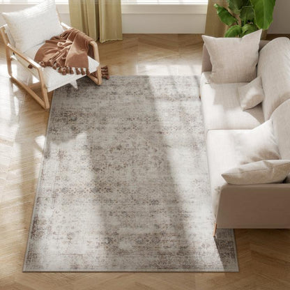 Light gray and dark brown distressed rectangular area rug on wood floor