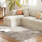 Gray and tan distressed area rug under beige sectional sofa