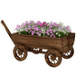 Wooden wagon planter box on four wheels with a long handle, filled with flowers