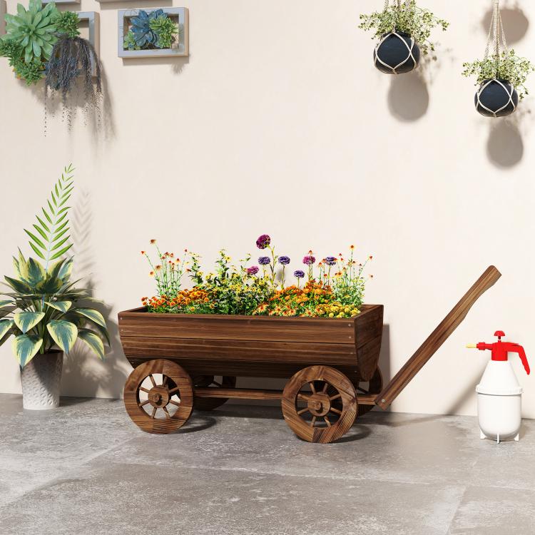 Wooden wagon planter with long handle and four wheels, filled with mixed flowers
