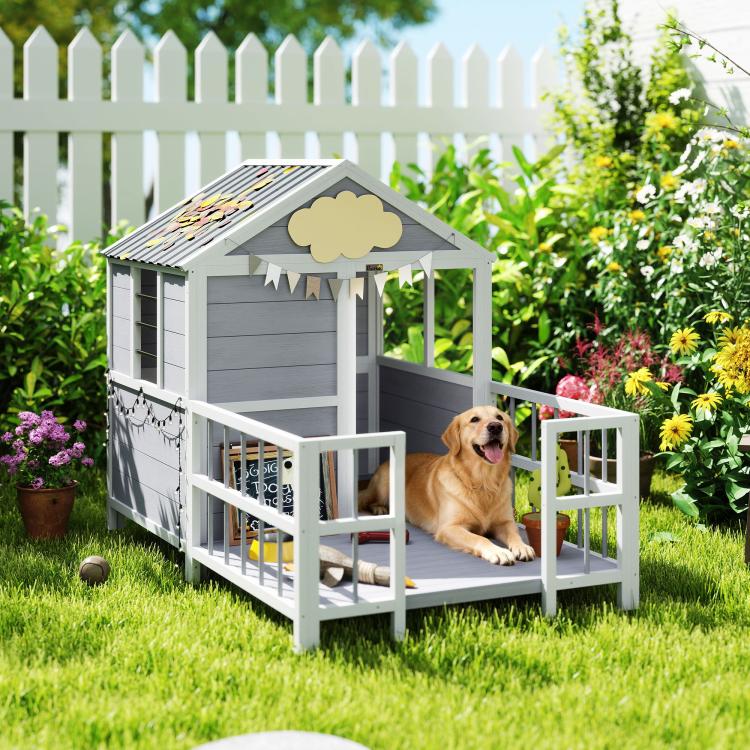 Elevated outdoor dog house with porch railings, gray siding, and dark roof.