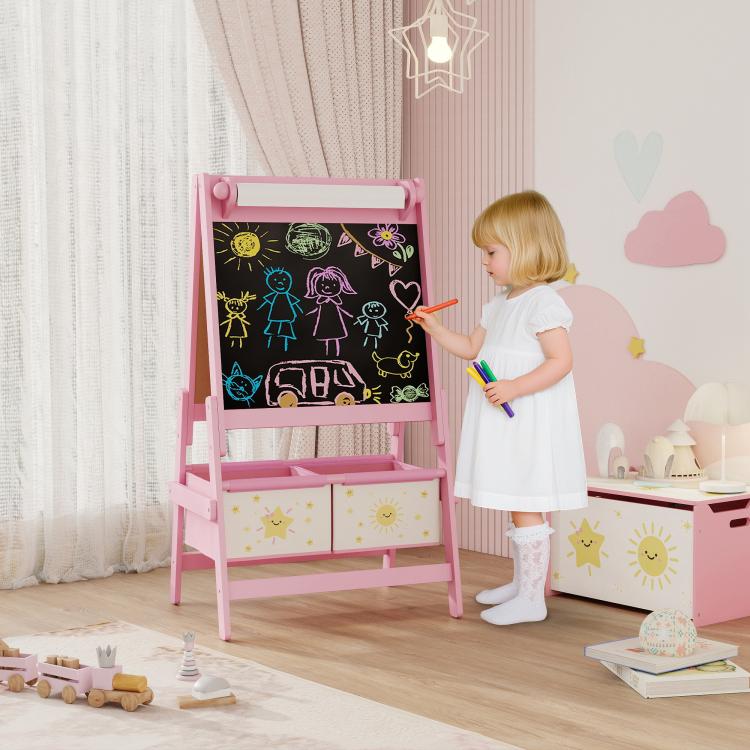 Pink kids art easel with chalkboard panel; child writing with chalk-like stick.