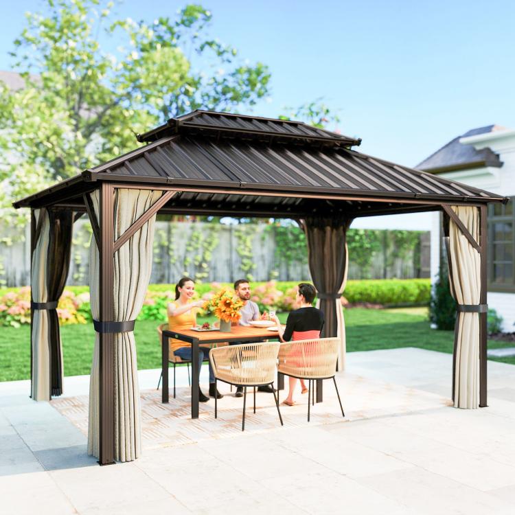 Brown hardtop gazebo with striped roof panels and hanging curtains around table