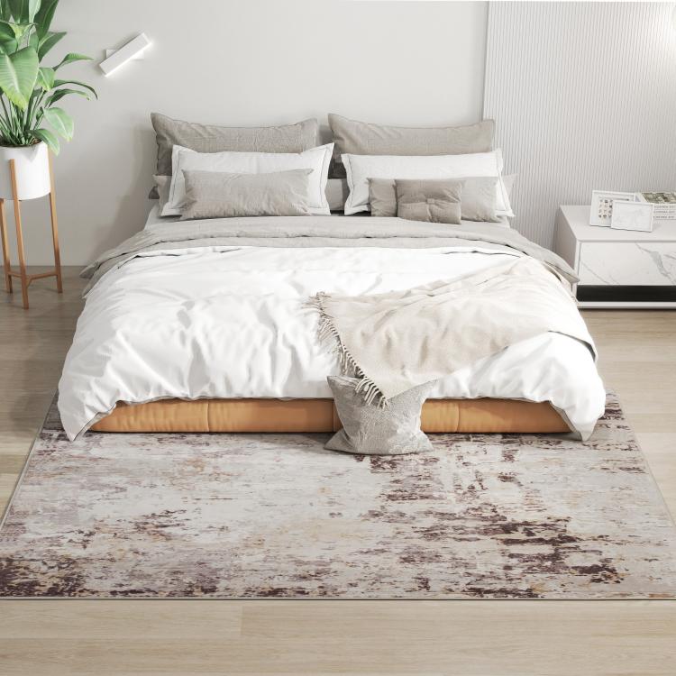Abstract area rug under bed, light base with brown distressed texture pattern