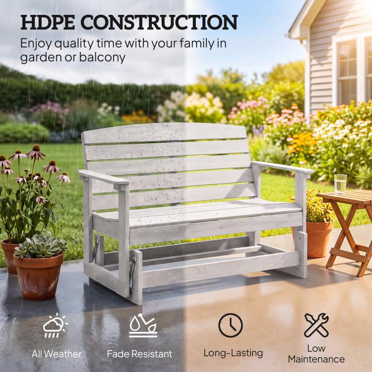 Distressed white slatted glider bench outdoors with armrests and rocking legs