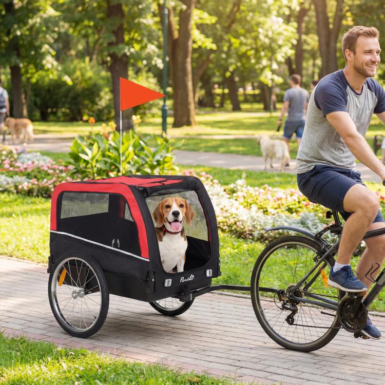 Dog bike trailer with red canopy, mesh sides, and a dog seated inside