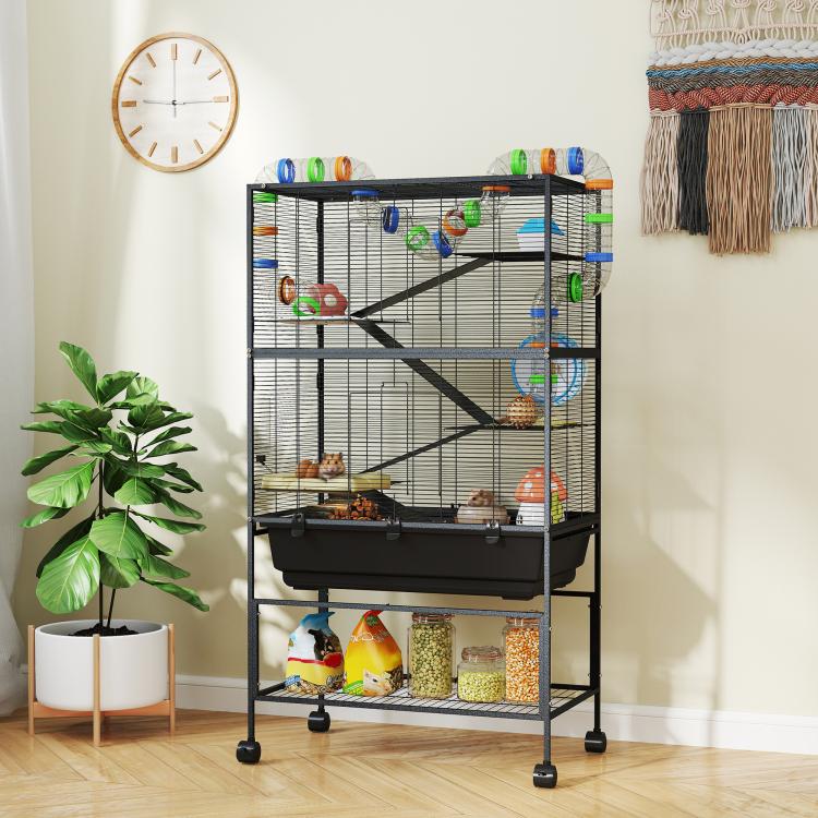 Multi-tier wire pet habitat with exercise wheel, hut, and front storage shelf