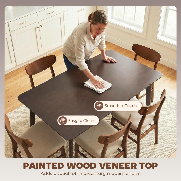 Dark brown dining table with chairs, being wiped clean with a cloth