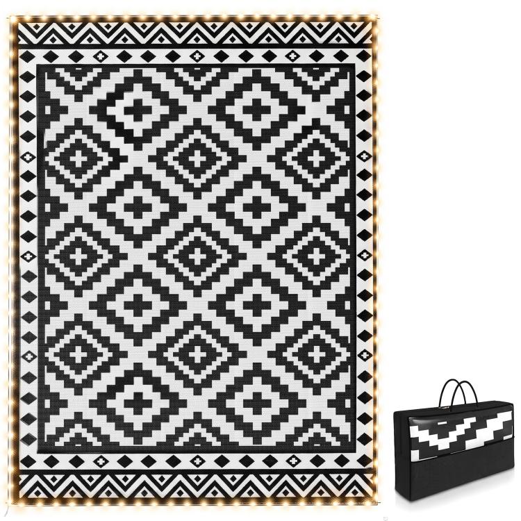 Outdoor reversible rug with black-and-white geometric pattern and LED string border