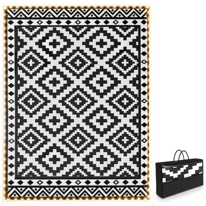 Outdoor reversible rug with black-and-white geometric pattern and LED string border
