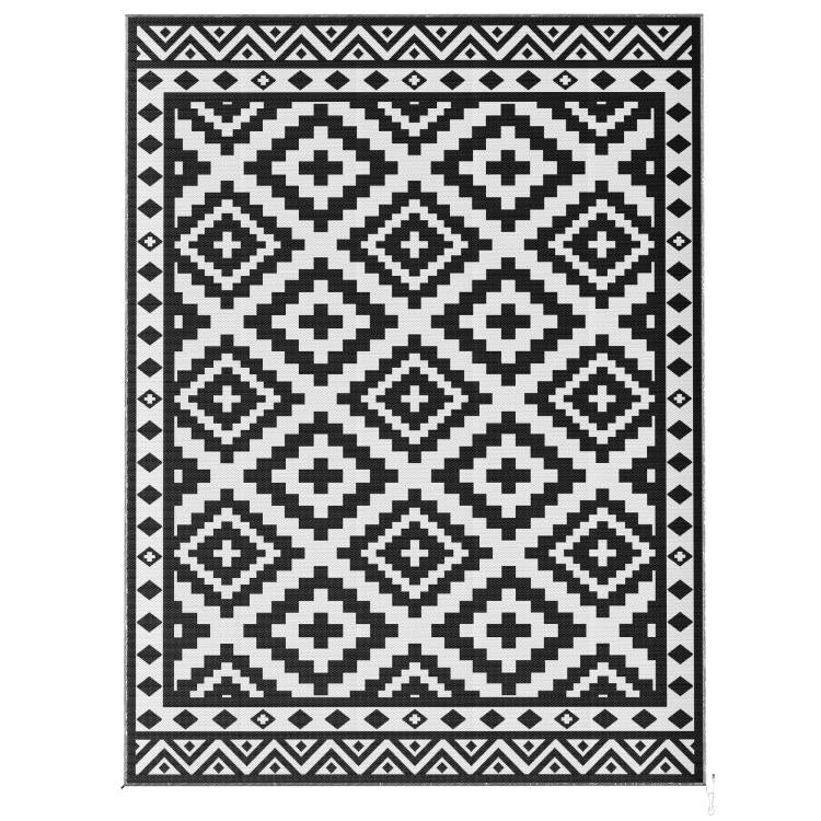 Outdoor reversible rug with black and white geometric diamond pattern