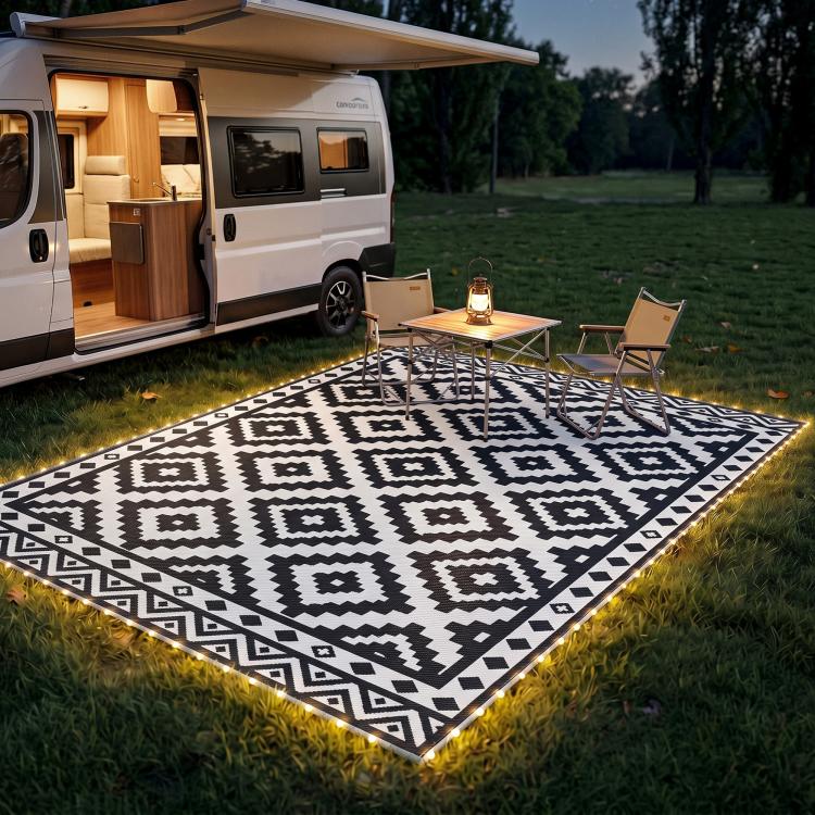 Outdoor black-and-white geometric rug with glowing LED border and patio seating