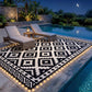 Black-and-white geometric outdoor rug with glowing LED border by a pool