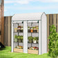 Small 3-tier mini greenhouse standing outdoors with two roll-up doors and multi-level wire racks