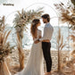 White metal wedding arch frame with dried pampas florals and standing couple