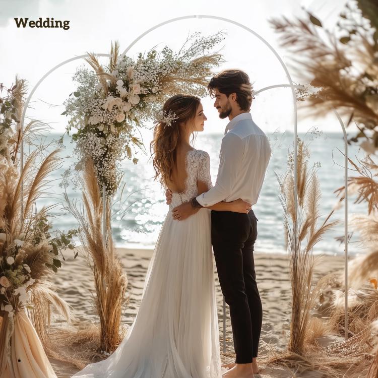 White metal wedding arch frame with dried pampas florals and standing couple