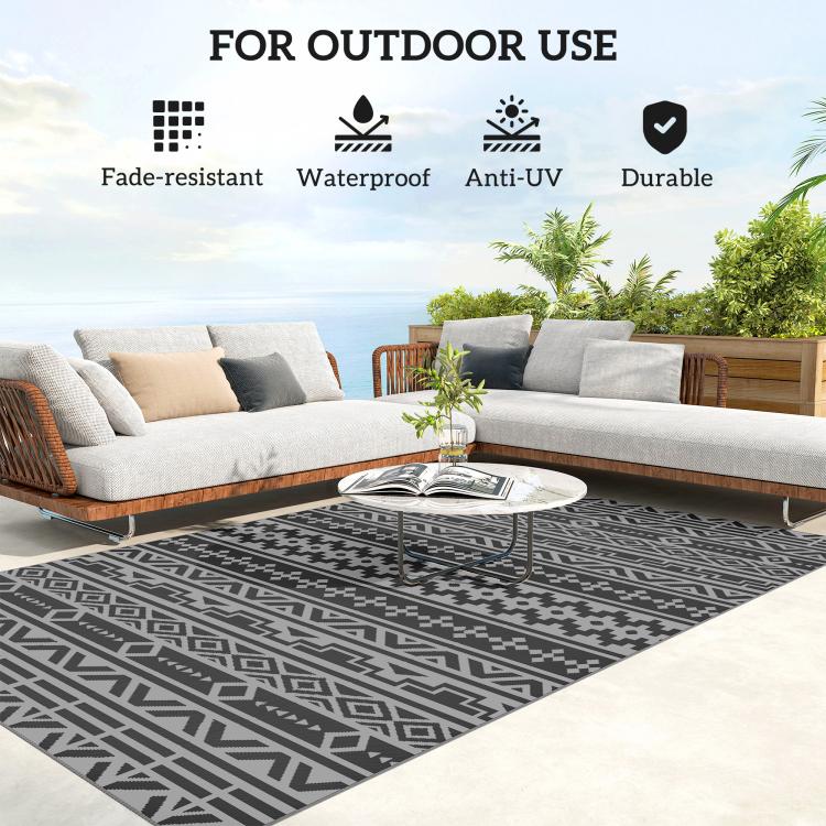Outdoor rug with black and gray geometric pattern beneath outdoor seating on patio