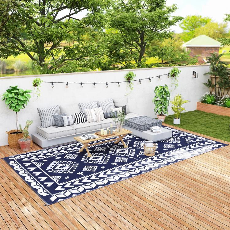 Outdoor reversible rug with blue-and-white geometric pattern and border