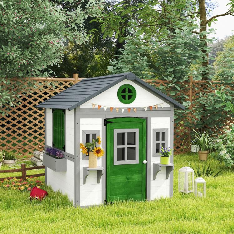 White wooden kids playhouse with green door and side windows, rooftop overhang and planters
