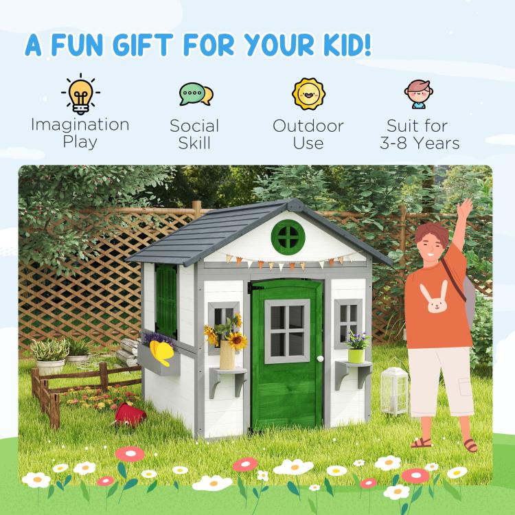 White wooden playhouse for kids with green door, windows, and rooftop overhang