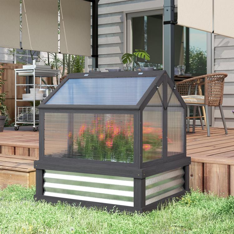 Gray raised greenhouse cold frame planter with clear window panels on grass