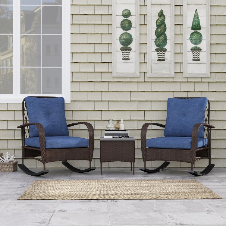 Brown wicker rocking chair set with two blue cushions and small coffee table