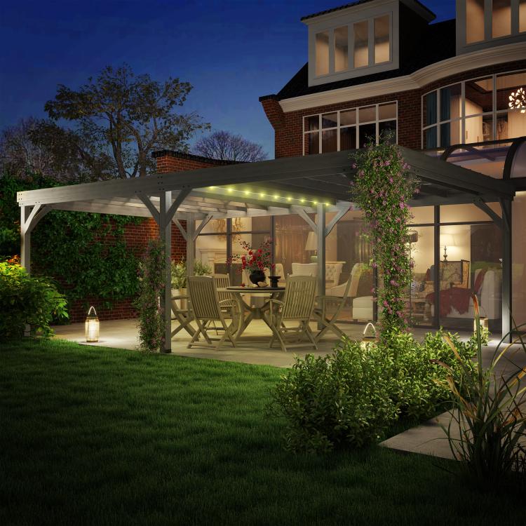 Gray outdoor wooden pergola with illuminated lights over patio seating at night