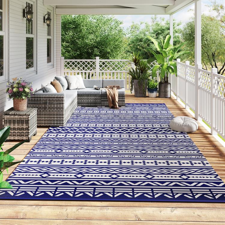 Reversible outdoor rug with blue-and-white geometric pattern, spread on patio