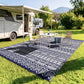 Reversible outdoor rug with blue-and-white geometric pattern, under outdoor dining set