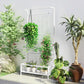 White trellis plant stand with hanging chain and bottom shelf holding multiple pots