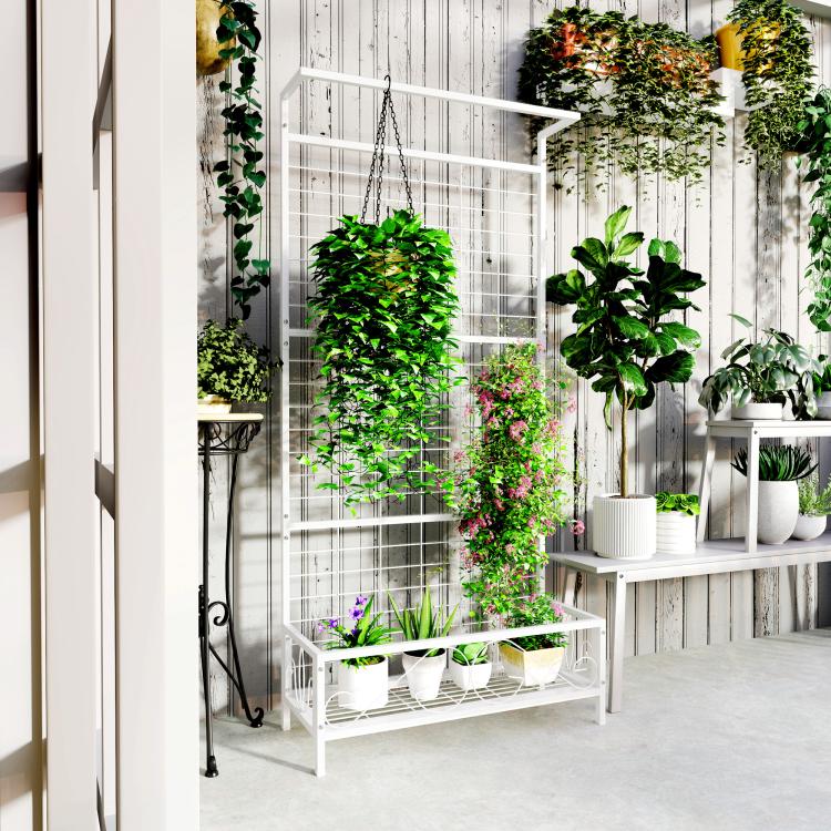 White metal vertical plant trellis with hanging chain and bottom shelf with potted greenery