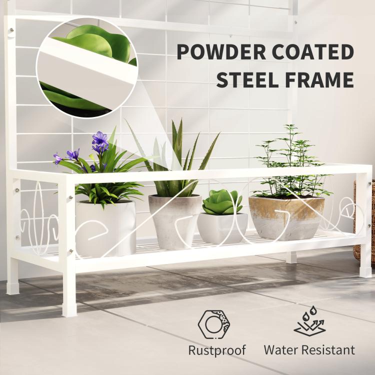 White metal plant stand with trellis back and front shelf holding potted plants