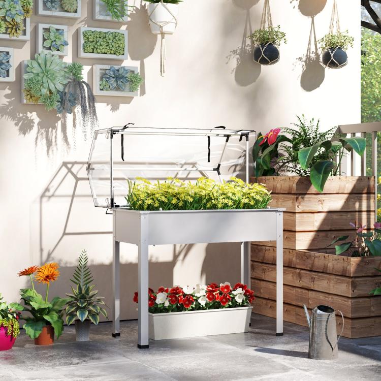 White raised garden bed greenhouse with clear cover and stacked planter trays inside