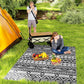 Black-and-white geometric outdoor rug laid on grass for camping
