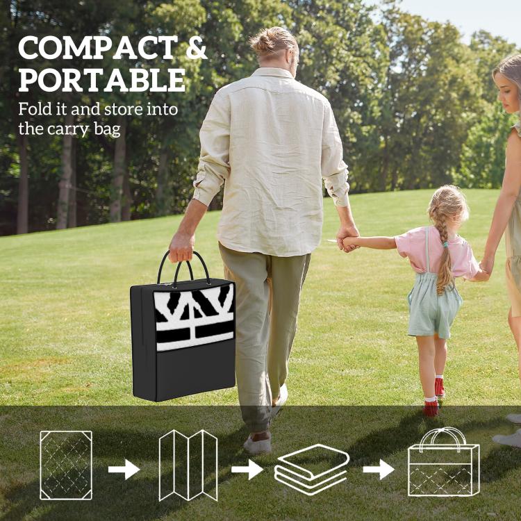 Folded black-and-white geometric outdoor rug with black carry bag