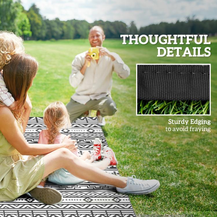 Black-and-white geometric outdoor rug with kids sitting on it