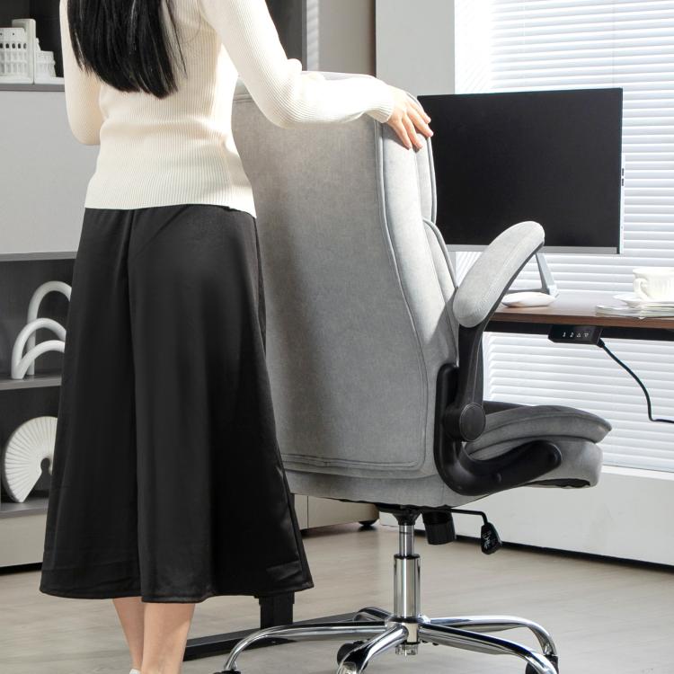 Gray chair with flip-up armrest and padded seat cushion on chrome base