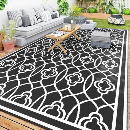 Outdoor reversible rug with black background and white clover trellis pattern