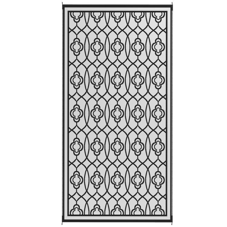 Reversible outdoor rug shown flat with black-and-white clover trellis design