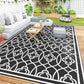 Large outdoor reversible rug featuring black background and white clover trellis pattern