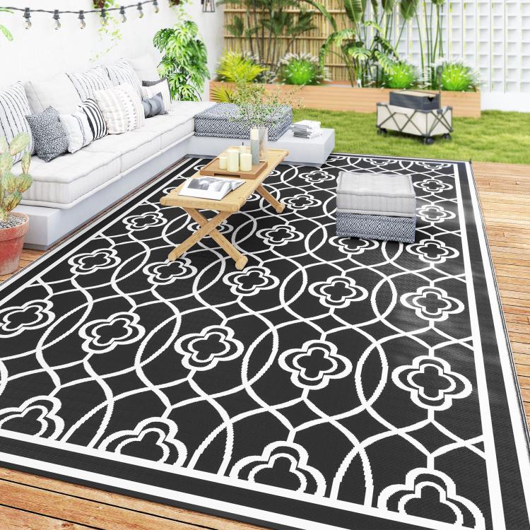 Large outdoor reversible rug featuring black background and white clover trellis pattern