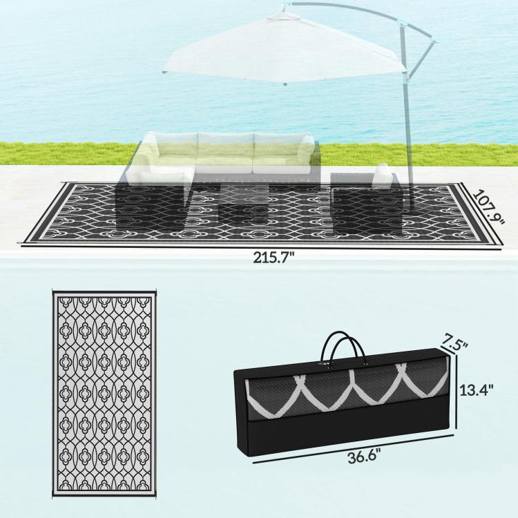 Reversible outdoor rug laid flat with black-and-white clover lattice pattern