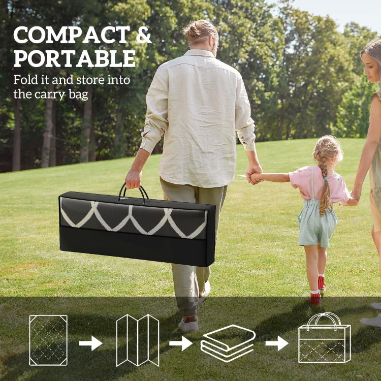 Compact folded outdoor rug in carry bag, black with white clover trim