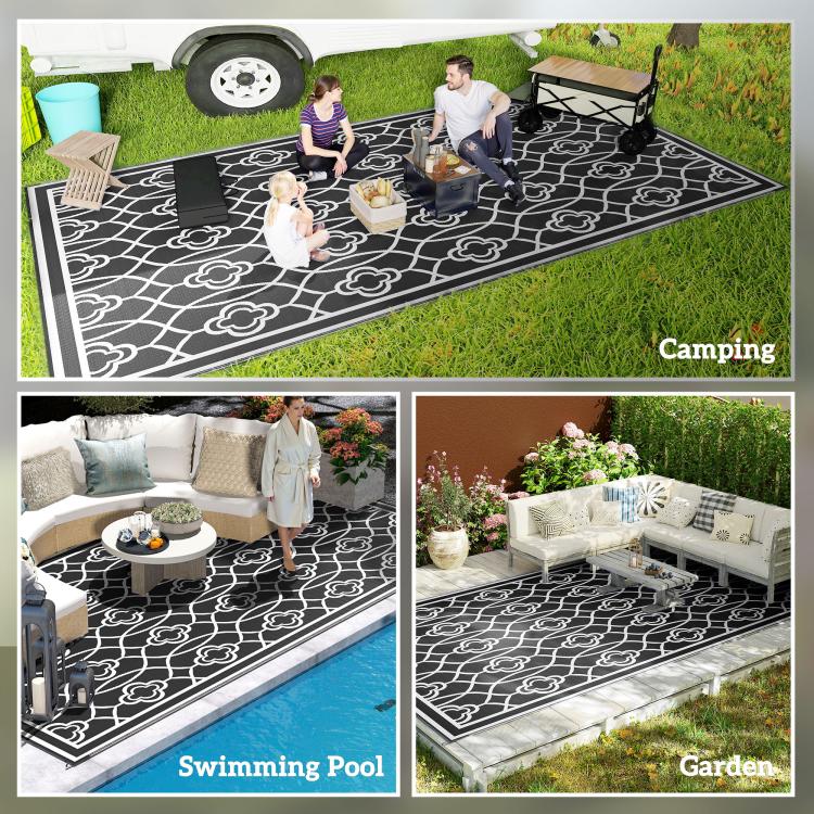 Outdoor reversible rug with black-and-white clover trellis pattern, wide view