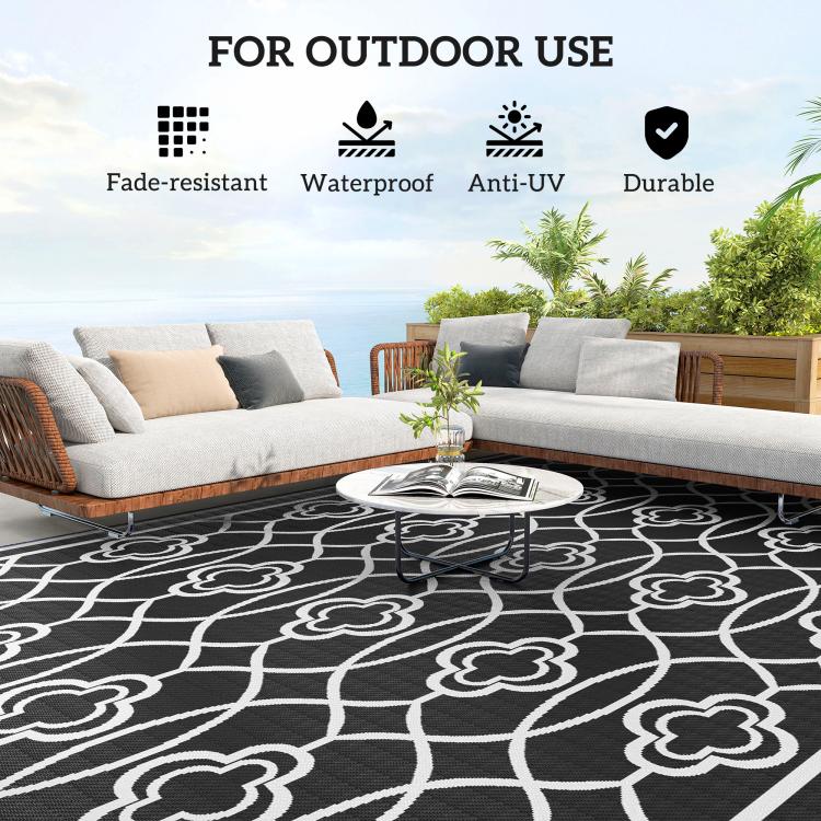 Outdoor reversible rug with black background and white clover trellis pattern