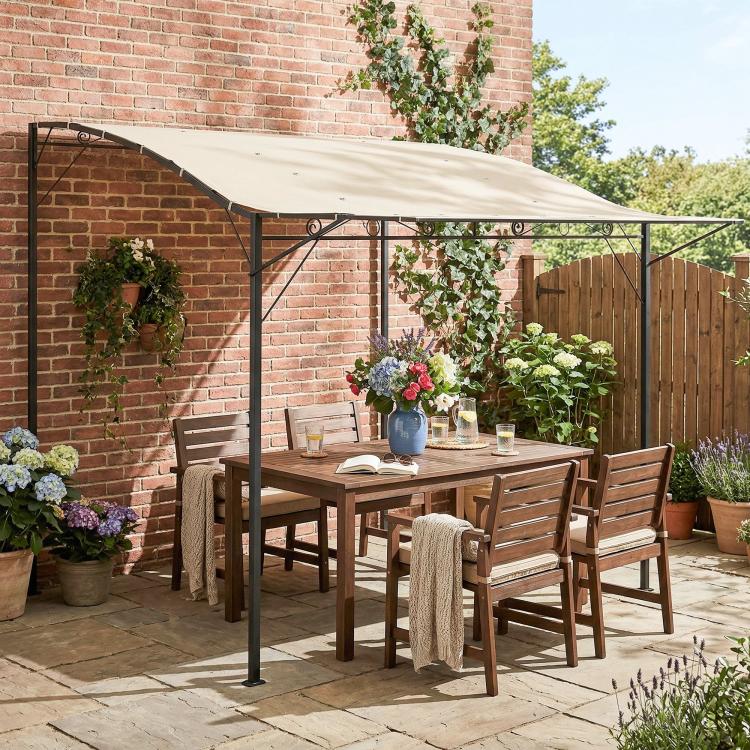 Outdoor gazebo over patio seating with cream white canopy and black support posts