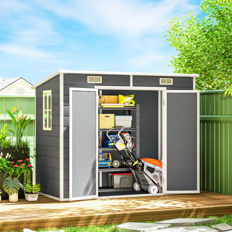 Gray plastic storage shed with wide open doors and shelves holding yard equipment