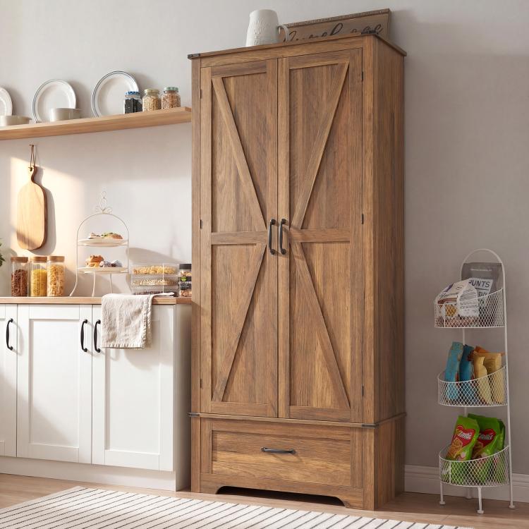 Brown farmhouse pantry cabinet with barn-style doors and bottom drawer